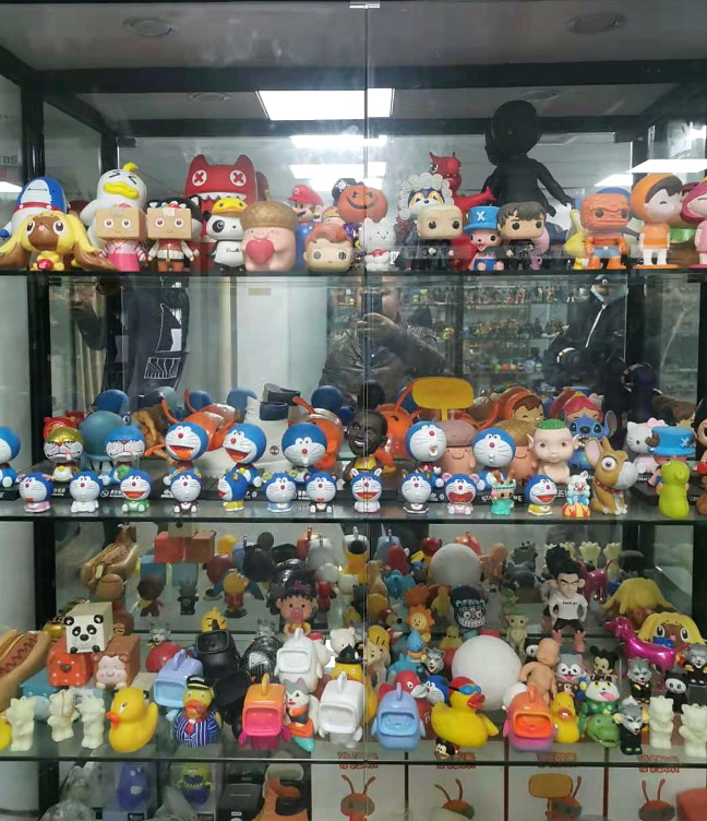 Close-up of custom PVC figurines and keyring samples displayed at the WINTEL Shenzhen showroom